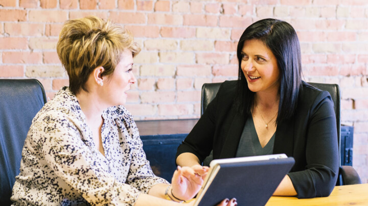 Two colleagues who seem to be in an informal conversation in the office