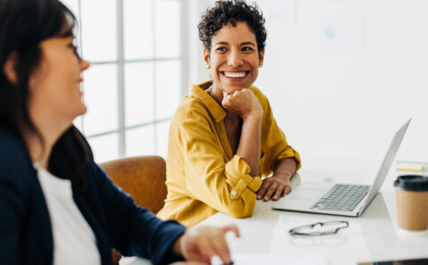 Happy business woman talking to her colleague in a meeting