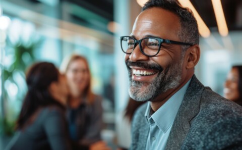 Mature businessman smiling while being among his colleagues