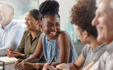 A group of employee laughing in a meeting