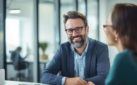 Happy business professional in a 1-2-1 with a happy female employee