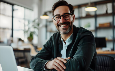 Smiling businessman working with his laptop in the office.