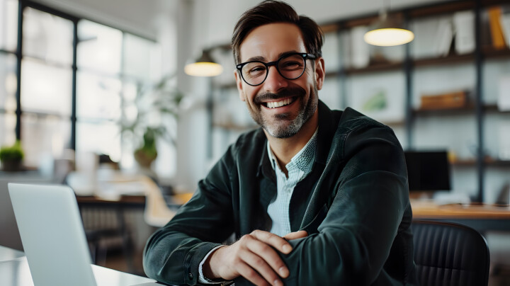 Smiling businessman working with his laptop in the office.